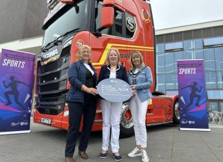 3 females standing in front of a Manfreight Limited lorry cab.