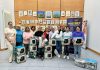 A group of people standing wth boxes containing air fryers and slow cookers, with a banner for Multiply