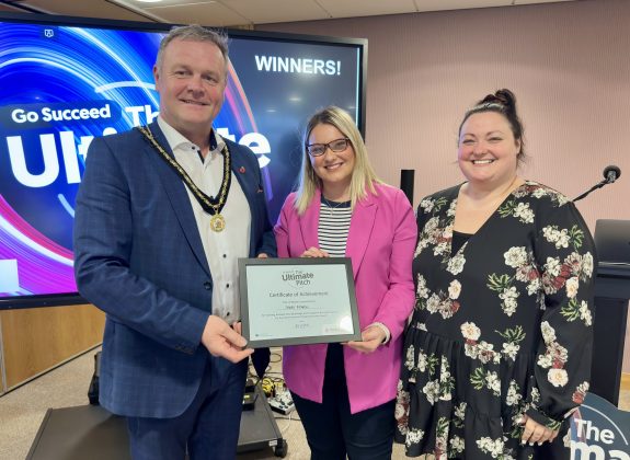 Three people holding a certificate