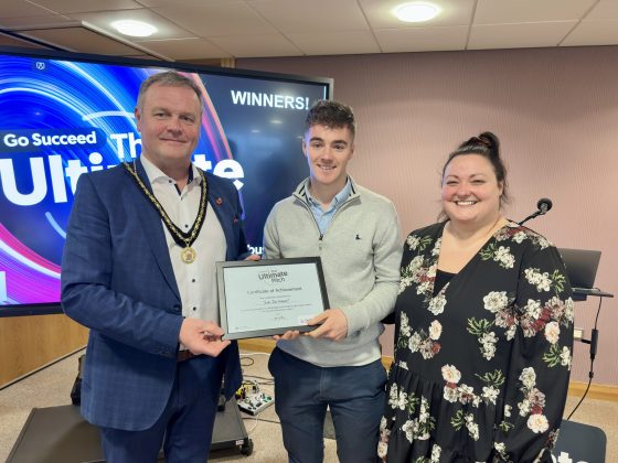 Three people holding a certificate