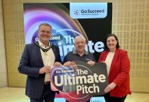 Three people holding a sign that says Ultimate Pitch, with a backdrop for Go Succeed Business Support