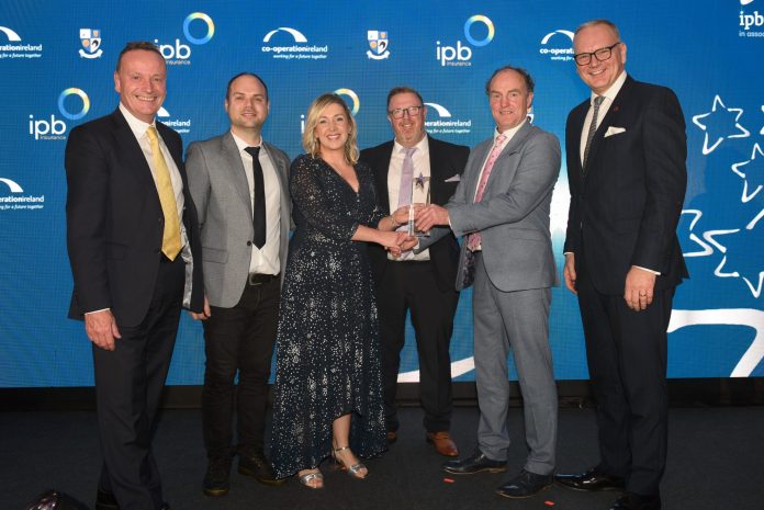 A group of people on stage receiving an award.