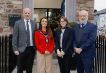 Four people standing outside a building, one of which is Lord Mayor wearing their chain.