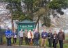 A number of people standing in a line in front of a sign that says Lurgan Park.