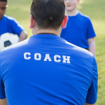 A sports coach taking a children's training session.