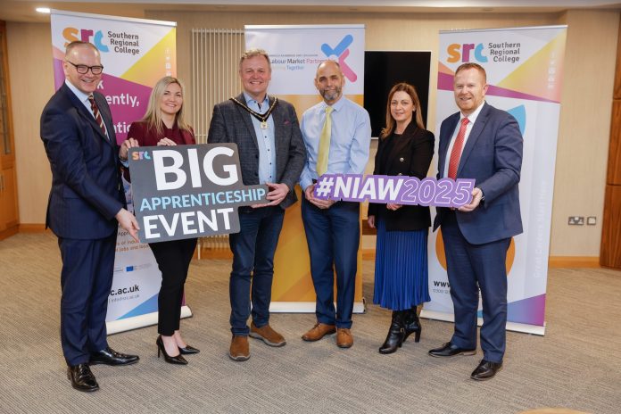 A group of people holding signs which say Big Apprenticeships Event and #NIAW 2025