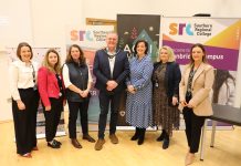 A group of people standing in front of education and food banners at a conference called Grow Together - Regenerating our Borough.