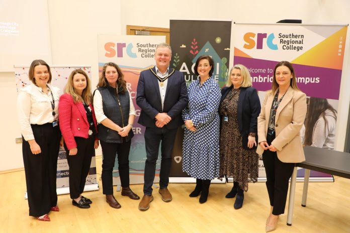 A group of people standing in front of education and food banners at a conference called Grow Together - Regenerating our Borough.