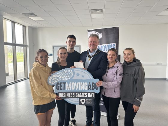 A group of people holding a sign saying Get Moving ABC Business Games Day